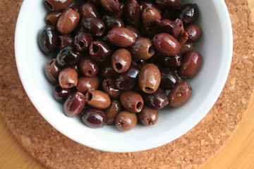 Italian Taggiasche olives in a bowl on wooden table
