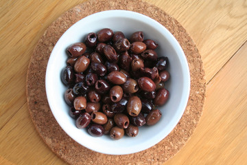 Italian Taggiasche olives in a bowl on wooden table