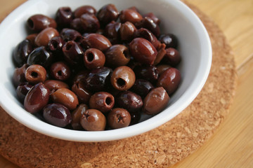 Italian Taggiasche olives in a bowl on wooden table