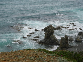 Fototapeta na wymiar rocky beach. rocky coast, clouds and waves. rock in the sea
