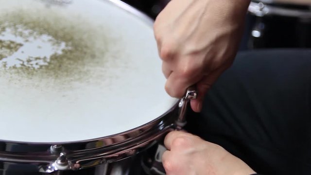 Drummer tunes the snare drum. Close-up