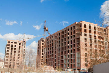 High-rise multi-storey buildings under construction. Tower cranes near building. Activity, architecture, development process, skyscraper