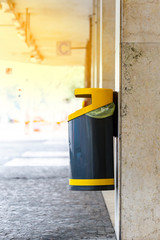 Black yellow plastic bin hanging on he wall