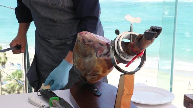 man cutting pata negra spanish ham