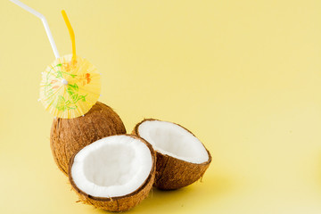 Fresh Coconut cocktail with a straws on yellow background, copy space