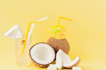 Fresh Coconut cocktail with a straws on yellow background