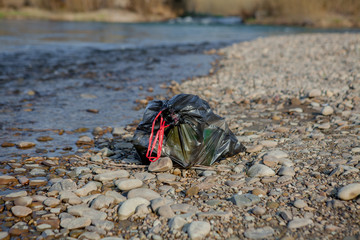 River pollution near the shore, garbage pack near the river, plastic food waste, contributing to pollution