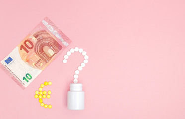 A question mark and euro mark laid out of pills and 10 euro on a pink background. Concept of medicine, money and health