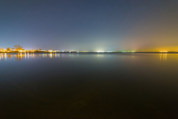 Lights of a small village on the beach at starry night