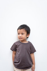 Portrait of a toddler boy wearing grey T-shirt with a little smile on white background