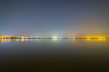 Lights of a small village on the beach at starry night
