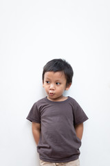 Portrait of a toddler boy with puckering facial expression on white background