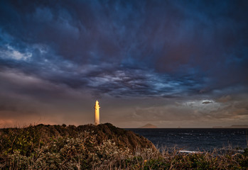 夕日に照らされる灯台