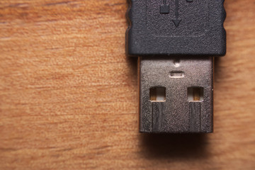 Single usb plug macro on wooden surface.