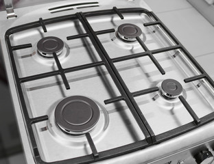 New modern gas stove with four burners for the kitchen, stainless steel surface, cast iron grates