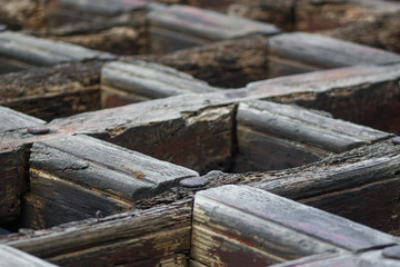 Background of a fragment of an old wooden gate. Wooden lattice in the form of diamonds. Wooden geometric background. The old wooden background. warm colors 