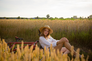 Beautiful woman in hat in summer field