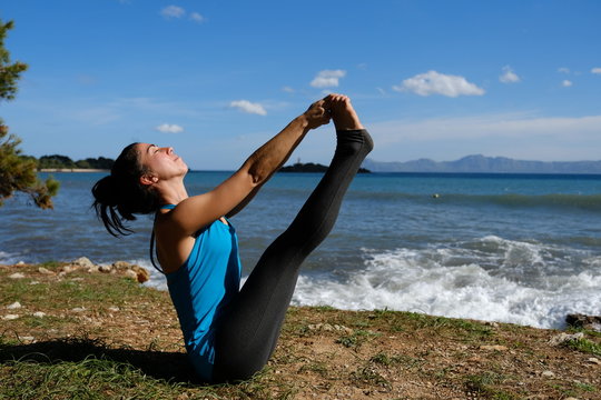 Mujer joven haciendo Yoga en la playa