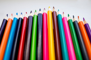 Fototapeta premium Color pencils on a white background, a line of colored pencils. Set of pencils. Children's creativity. Drawing with pencils