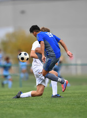 Young teen boys playing soccer