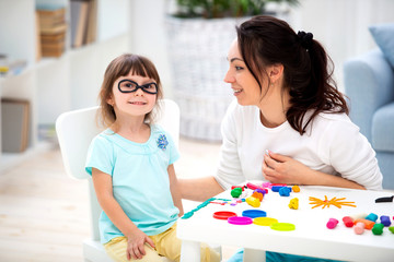 Naklejka premium How to save healthy eyesight. Mom and daughter make glasses from plasticine