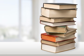 Stack of books with laptop on table