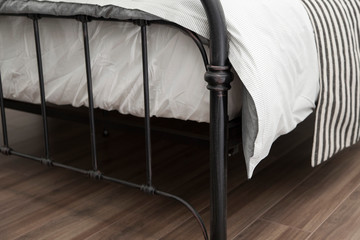 close up of bedding iron frame with white comfortable blanket and mattress