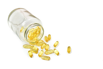 Close up of fish oil capsules isolated in big jar glass on white background. Salmon fish capsules view. Omega 3. Vitamin E. Supplement food background.