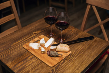 Red wine and assorted cheese plate with sausage