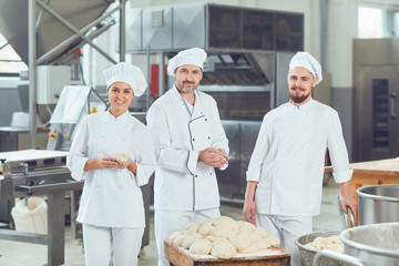 A group of bakers smiles at the bakery