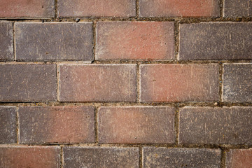 Even rows of red brown pavement tiles with scratched texture. Abstract background