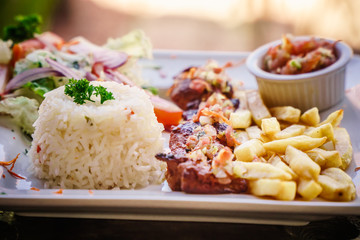 steak served in a restaurant dish with frites and rice