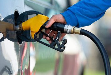 Man filling gasoline fuel in car holding nozzle