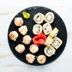 Sushi and maki rolls on a plate. Top view. Free space for your text. On a white background.