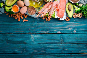 Balanced Keto diet. Healthy food: avocado, fish, shrimp, broccoli, flax, nuts, egg, parsley. Top view. Free space for your text.
