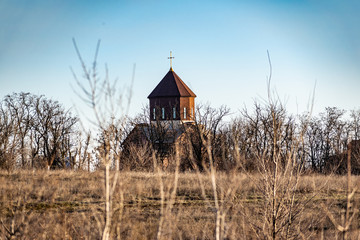 A small simple Orthodox Church, stands alone in the distance, among the fields and numerous...