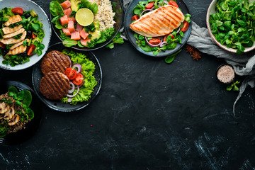 Assortment of food. Folk cuisine on a black wooden background Top view. Free space for your text....