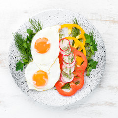 Breakfast. Fried eggs with vegetables. Top view. Free copy space.