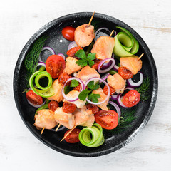 Chicken kebab with vegetables. Kebab in a black plate. Top view. Free copy space.