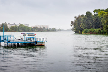 Boat for walks  on the pier. Lake in the city park_