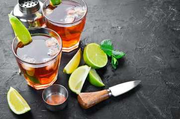 Alcoholic Beverage Rum, lime and mint on a black stone background. Top view. Free space for your text.