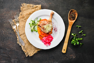 Baked chicken thigh with pumpkin puree. In the plate. Top view. Free space for your text. Rustic style.