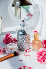 Obraz na płótnie Canvas Perfume, foundation cream, brush and reflection with dianthus flowers