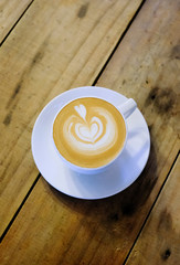 Cups of cafe latte on wooden table background