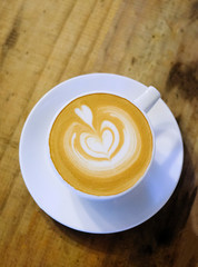 Cups of cafe latte on wooden table background