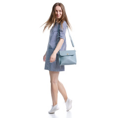 Woman in blue dress with bag looking on white background isolation