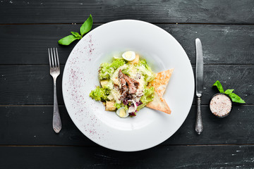 Vegetable Caesar Salad with Veal. In the plate. Top view. Free space for your text. Rustic style.