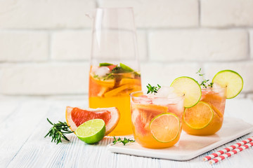Refreshing iced citrus mocktail on light blue background. Selective focus, space for text.