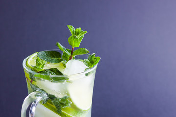 Mojito on black background. Mojito cocktail with lime and fresh mint on slate board. Summer refreshing cocktail with citrus on dark background. Copy space