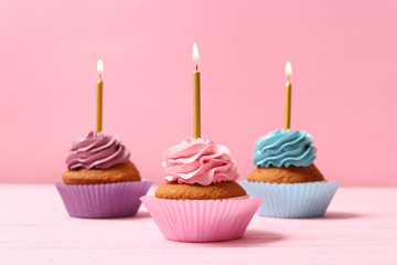 Delicious cupcakes with candles on a colored background. Festive background, birthday